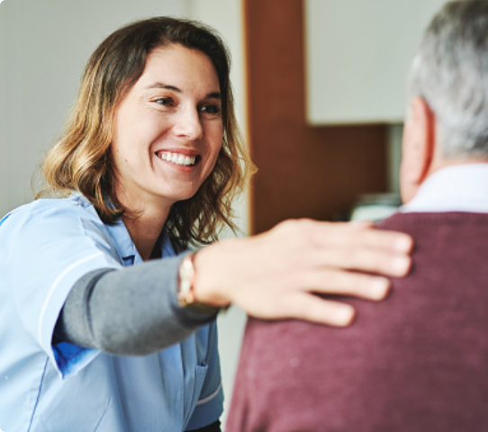 Social worker woman putting hand on older mans shoulder