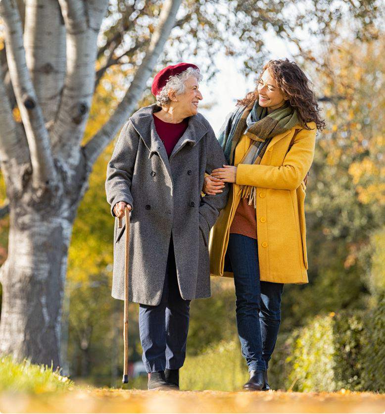 Middle aged woman walking with an older woman in the fall